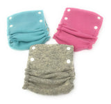 Three Babee Greens cashmere and wool diaper covers in blue, pink, and gray.